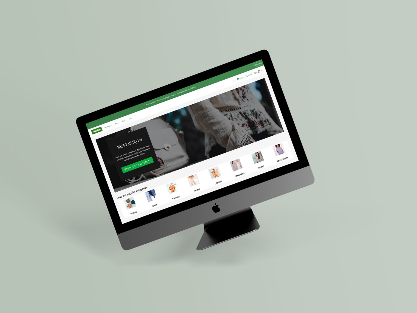 Mac desktop monitor with a clothing e-commerce website on screen. The website uses green colours.